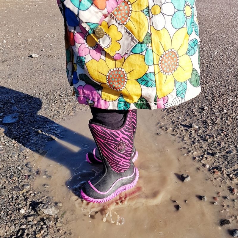 Littlest splashing in a puddle with her Muckboots