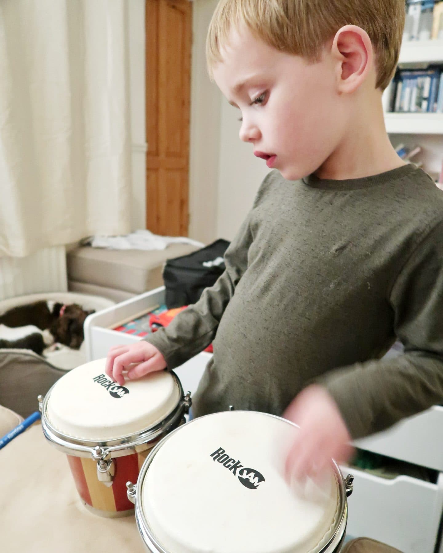 My five year-old son playing with his bongos - gifts for autistic children