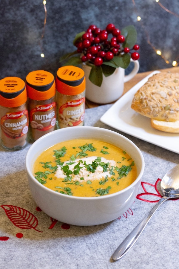 Portrait picture of soup, roll and spices - butternut sqush soup