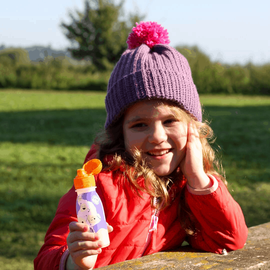 Small girl outdoors wearing a purple crochet hat