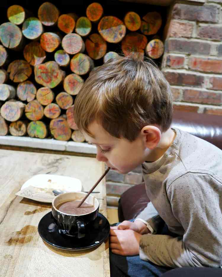 Boy drinking hot chocolate from a straw