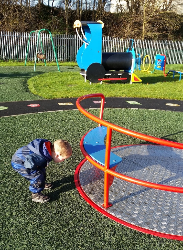 boy looking at roundabout spin